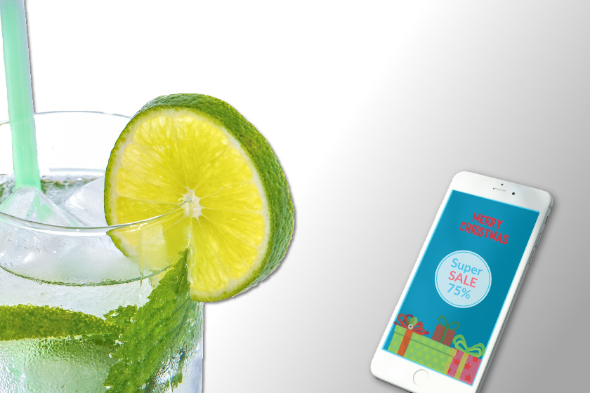 Das Bild zeigt einen Sommer-Drink und ein Smartphone mit Weihnachts-Angeboten.