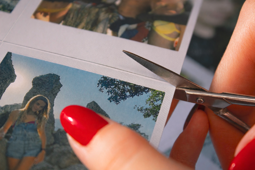 Analoge Fotos werden mit einer Schere zurecht geschniten